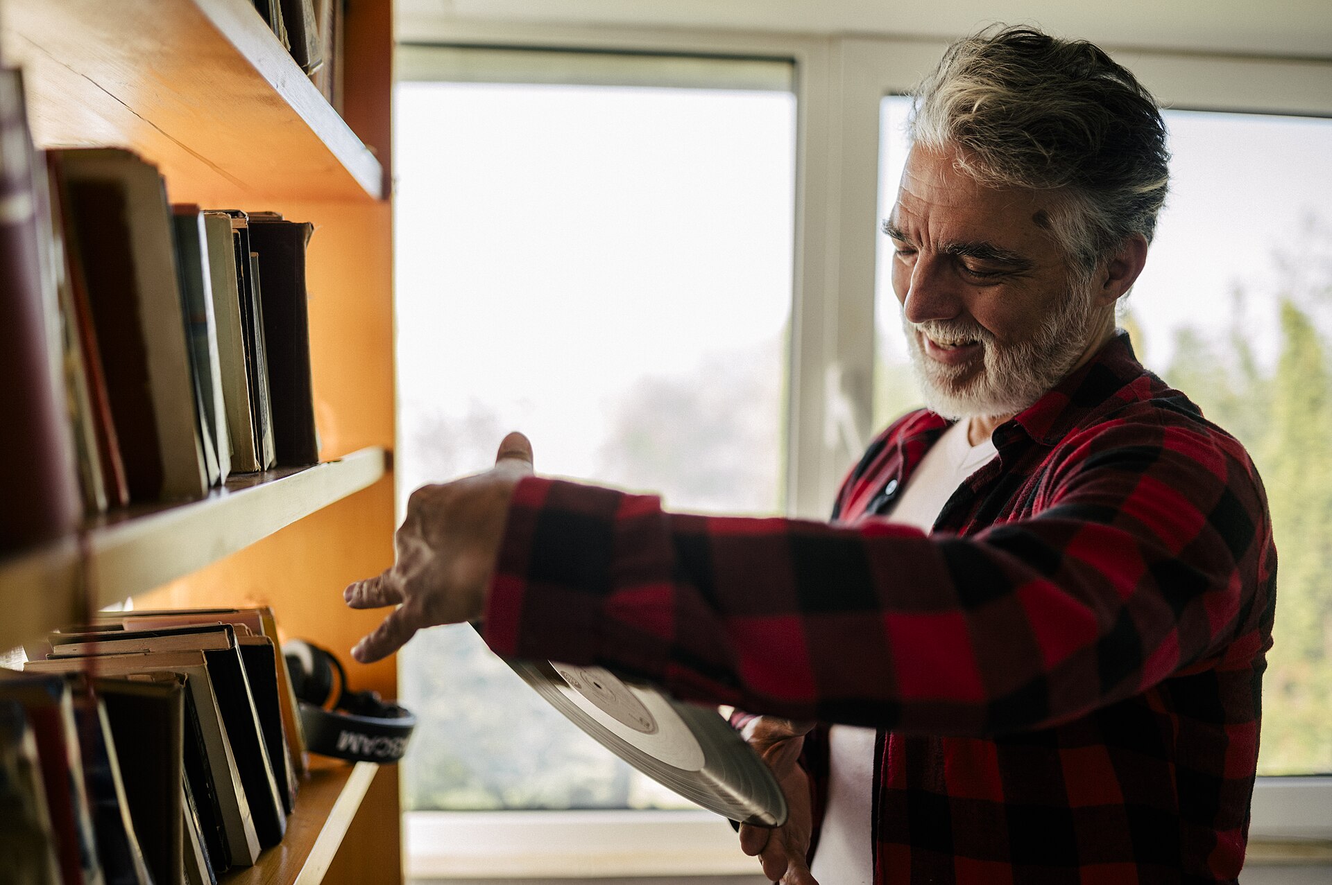 Organizing vinyl records in front of a bookshelf